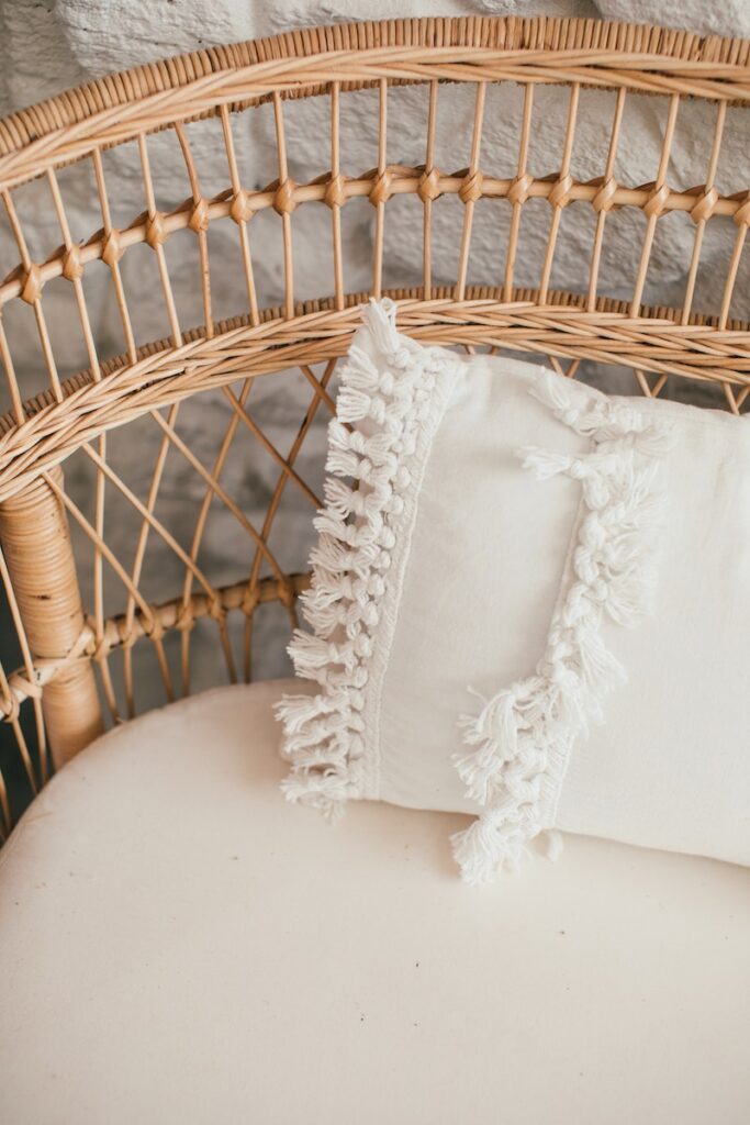 Wicker couch with decorative cushion in daylight